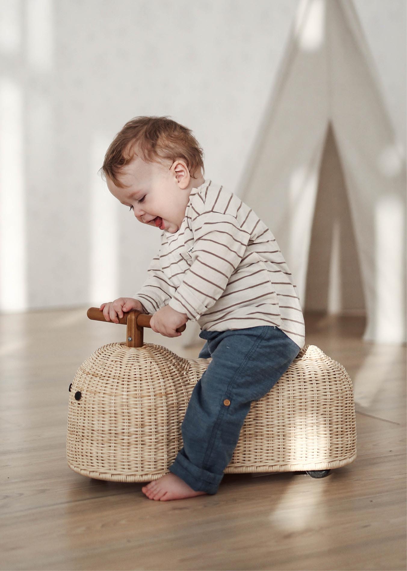 Child playing with Ride On Toy made of Rattan